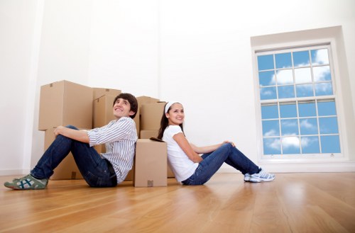 Removal van and movers handling furniture in a Barnes street
